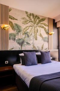 戛纳Hôtel Gallia Cannes的一间卧室配有一张带壁画的大床