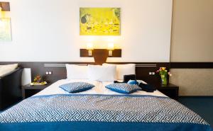 索非亚索非亚格拉米酒店的卧室配有蓝色和白色的床和2个枕头