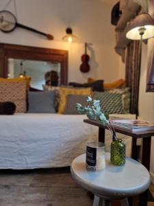塔朗斯Albin le musicien的一间卧室配有一张床和一张带花瓶的桌子