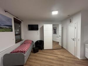 斯图加特Aparthotel Waldhorn Wohnung Allgäustyle的一间卧室配有一张床和一台电视