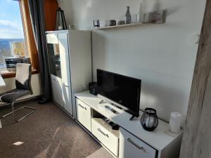 石勒苏益格Ferienwohnung NABOO的一间客厅,客厅的白色橱柜上配有电视