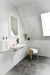 KåsebergaKåseberga Gårdshotell & Spa的白色的浴室设有水槽和镜子