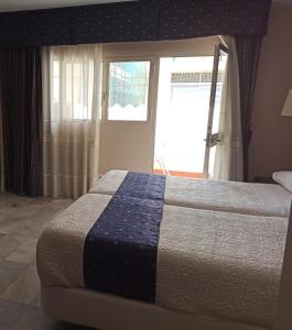 马拉加卡斯蒂亚格雷罗酒店的一间卧室配有一张带蓝白色毯子的床