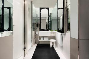 新加坡JW Marriott Hotel Singapore South Beach的浴室设有白色浴缸、水槽和镜子