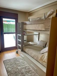 费莱乔萨APARTAMENTO FELECHOSA的卧室配有两张双层床和地毯。