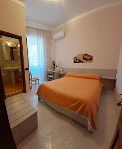 萨莱诺圣罗莎住宿加早餐旅馆的一间带橙色床的卧室和一间浴室