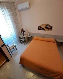 萨莱诺圣罗莎住宿加早餐旅馆的一间卧室配有橙色的床和桌子