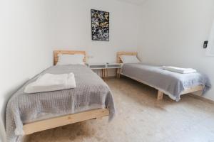 耶路撒冷ARISTO Machne Yehuda boutique apartments的一间卧室配有两张床和一张桌子