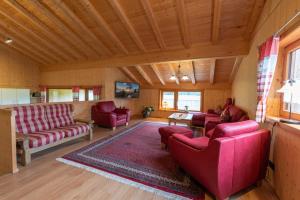 奥伯斯特多夫Ferienwohnungen Weiler的客厅配有红色家具和木制天花板