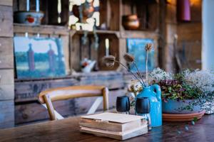 斯欣奥普赫尔Geulzicht Hotel的一张带蓝色花瓶的木桌,上面有书籍和鲜花