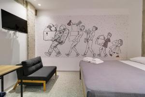 雅典athensdot的卧室配有一张床和墙上的绘画