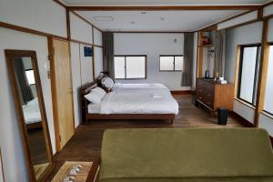 沼津Tagore Harbor Hostel的一间卧室配有一张床和一面大镜子