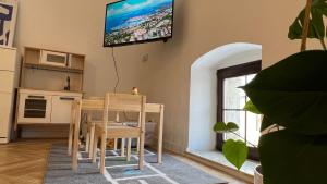 凯日马罗克Franco Apartments的客厅配有桌子和墙上的电视