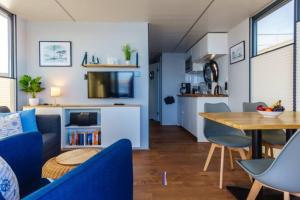 巴特Hausboot Fjord POLARIS mit Biosauna in Barth的客厅配有蓝色的沙发和桌子