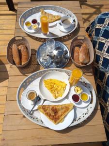 塔姆拉赫特乌兹达尔Santacruz Hostel的一张桌子,上面有三盘早餐食品