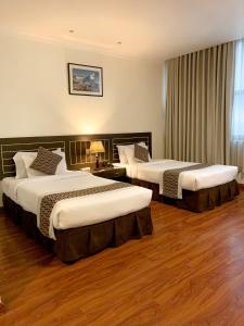 加德满都Vannasut Hotel and Spa的配有2张床的酒店客房,铺有木地板