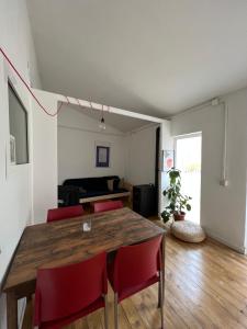EsparragueraPrecioso apartamento en el centro de Esparreguera的一间带木桌和红色椅子的用餐室