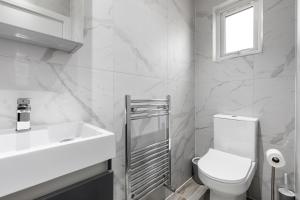 The HydeStar London Station Road 3-Bed Oasis with Garden的白色的浴室设有卫生间和水槽。