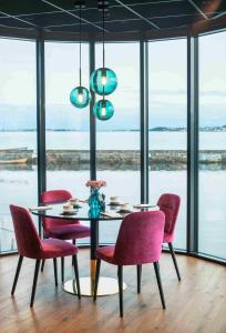 奥勒松Thon Hotel Ålesund的一间带桌子和红色椅子的用餐室
