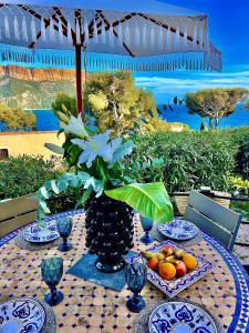 卡西斯Astoria Villa maison d hôtes Appartement vue mer avec piscine的水果盘和花瓶的桌子