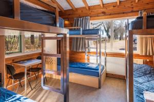 GorsselStayokay Hostel Gorssel - Deventer的客房设有双层床和桌椅。