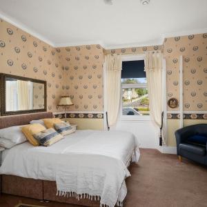邓迪阿什利酒店的一间卧室设有一张大床和一个窗户。