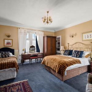 邓迪阿什利酒店的一间卧室配有两张床和一张书桌