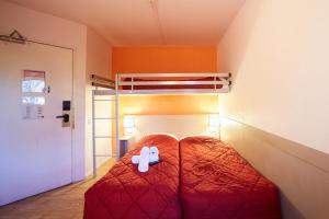 亚眠亚眠高级酒店的卧室配有红色的床,里面装有白色填充物动物
