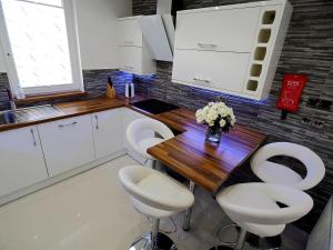 阿伯丁Private Room in Modern Apartment的厨房配有木桌和白色椅子
