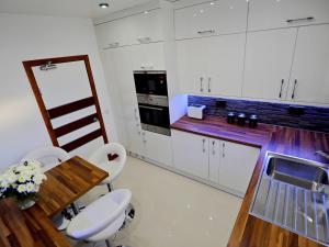 阿伯丁Private Room in Modern Apartment的厨房配有白色橱柜和木桌及椅子