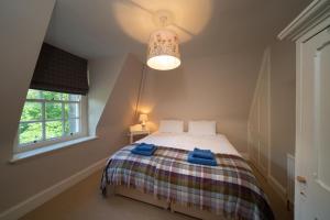 Gatehouse, Bridge of Balgie, Glenlyon的一间卧室配有一张带蓝色毛巾的床