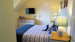 Port na LongBracadale House的一间卧室配有一张床和一张带台灯的桌子