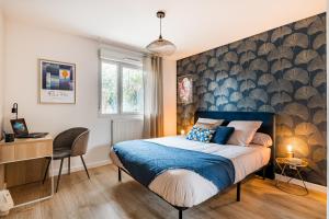 圣普列斯特Le Nouveau Monde - Appartement Chic et Confortable的一间卧室配有一张床、一张书桌和一个窗户。