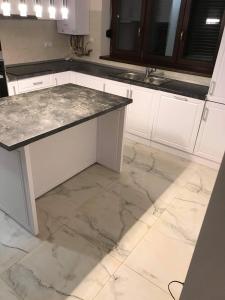 梅迪亚什Concept Urban的厨房配有白色橱柜和大理石台面