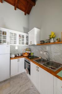 LjaknasiBlerina Farm House的厨房配有白色橱柜和水槽