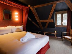 圣于尔萨讷Peanut Medieval Lodge的配有一张床和一把椅子的酒店客房
