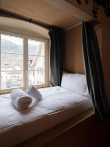 圣于尔萨讷Peanut Medieval Lodge的窗户前的一张带毛巾的床