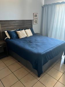 阿曼济姆托蒂L’Escalier Cabanas 510的一张带蓝色棉被和枕头的床