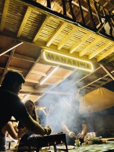 塔奈Manariwa - Exclusive Camp site的一群人在餐馆准备食物