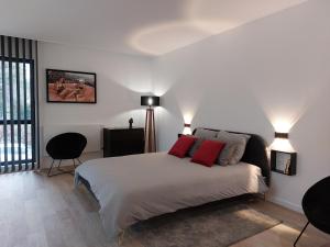 亚眠Urbs Amiens Sud的一间卧室配有一张带两个红色枕头的床