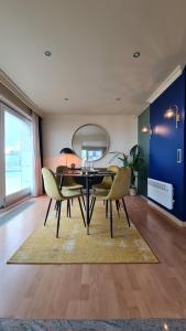 奥斯坦德Maui - zeezichtappartement te Oostende的一间用餐室,配有一张黑桌子和黄色椅子