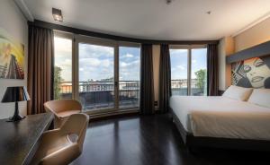 米兰米兰皇冠广场酒店的酒店客房设有一张床、一张书桌和窗户。
