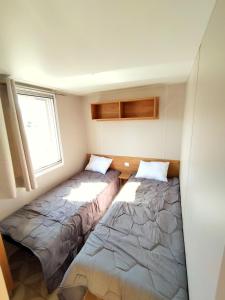瓦尔拉普拉日Mobil-Home Eucalyptus Valras-Plage的小型客房 - 带2张床和窗户
