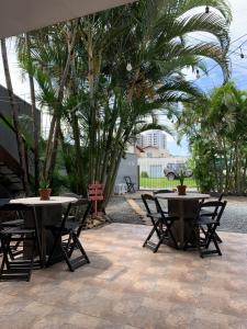 伊达贾伊Fica, Vai ter Bolo Hostel的两把桌椅,位于种有棕榈树的庭院