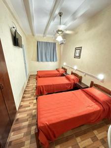 布宜诺斯艾利斯Centro1555的红色床单的客房内的三张床