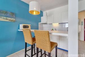 克拉伦代克博内尔岛海滨公寓的厨房配有两把椅子和带微波炉的台面