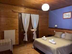 埃尔卡拉法特霍斯特里亚海宁酒店的一间卧室设有两张床和蓝色的墙壁