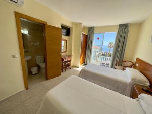 多列毛利诺斯Hotel Cabello的酒店客房设有两张床和一个阳台。