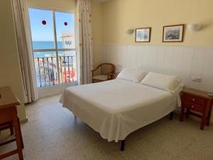 多列毛利诺斯Hotel Cabello的一间卧室配有一张床,享有海景