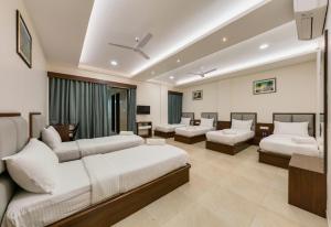 KudālHotel Aaradhya Adorer的酒店客房,设有两张床和一张沙发